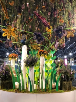 Flower Power Floral Display with flowers hanging from the ceiling and larger floral pieces on the ground