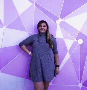 Girl posing infront of Disney purple wall