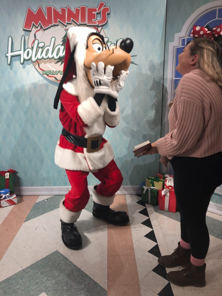 Woman meeting Goofy dressed as Santa Clause.