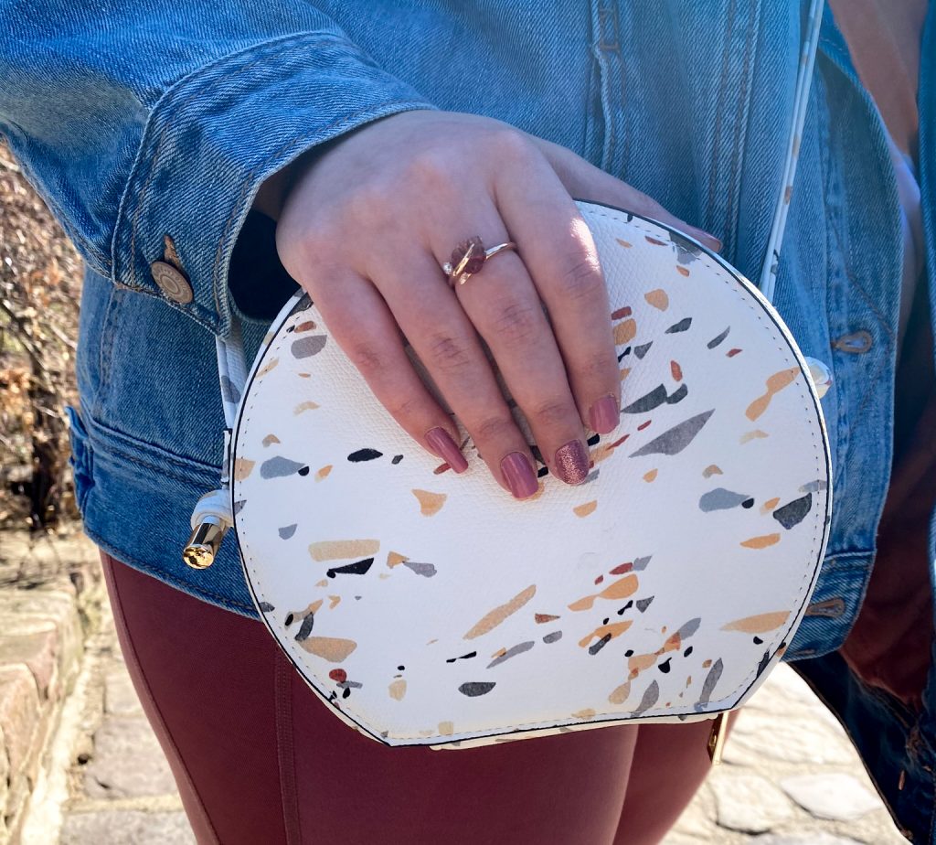 woman's hand on white speckled purse
