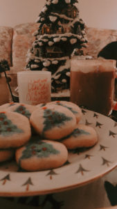 Cookies and Hot Chocolate infront of Christmas tree statue